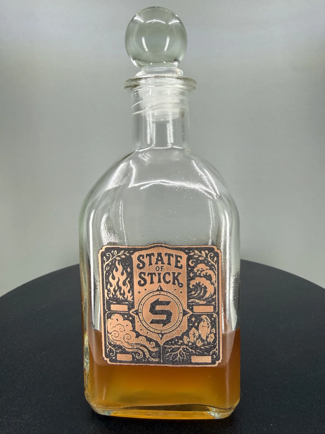 Custom Cauldron glass bottle with a dimensional State of Stick, Co. emblem